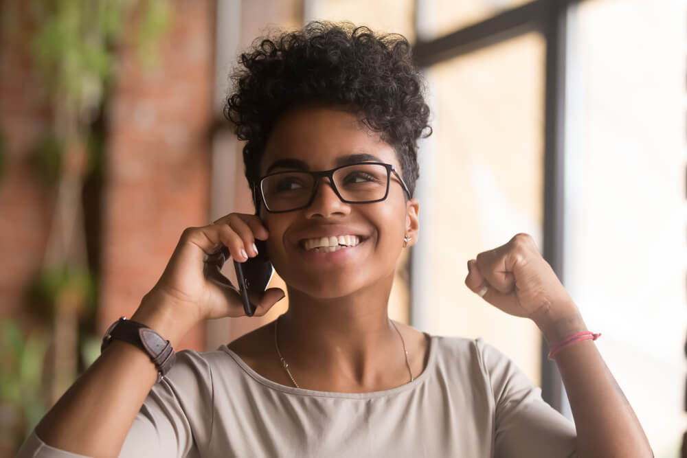 garota feliz recebdno contato de empresa por telefone no processo de pós venda