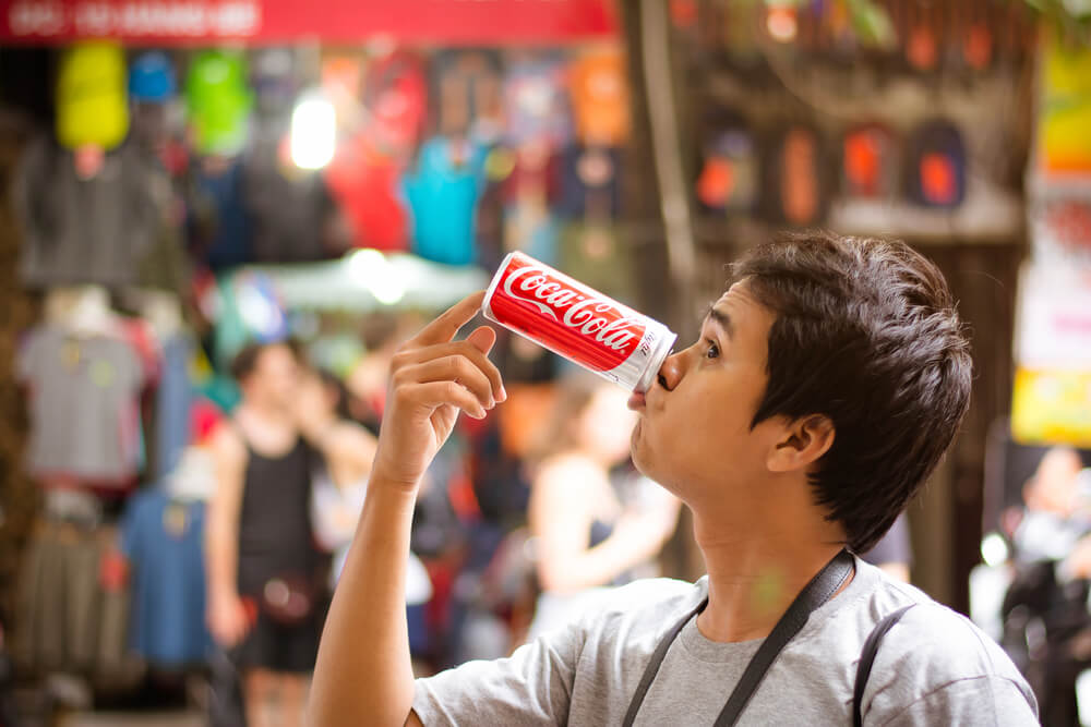 garoto brincando com lata de coca cola empresa que utiliza marketing 4.0