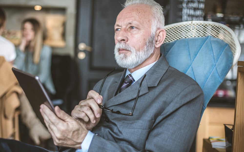 homem sério em contato com a era digital por meio de um tablet