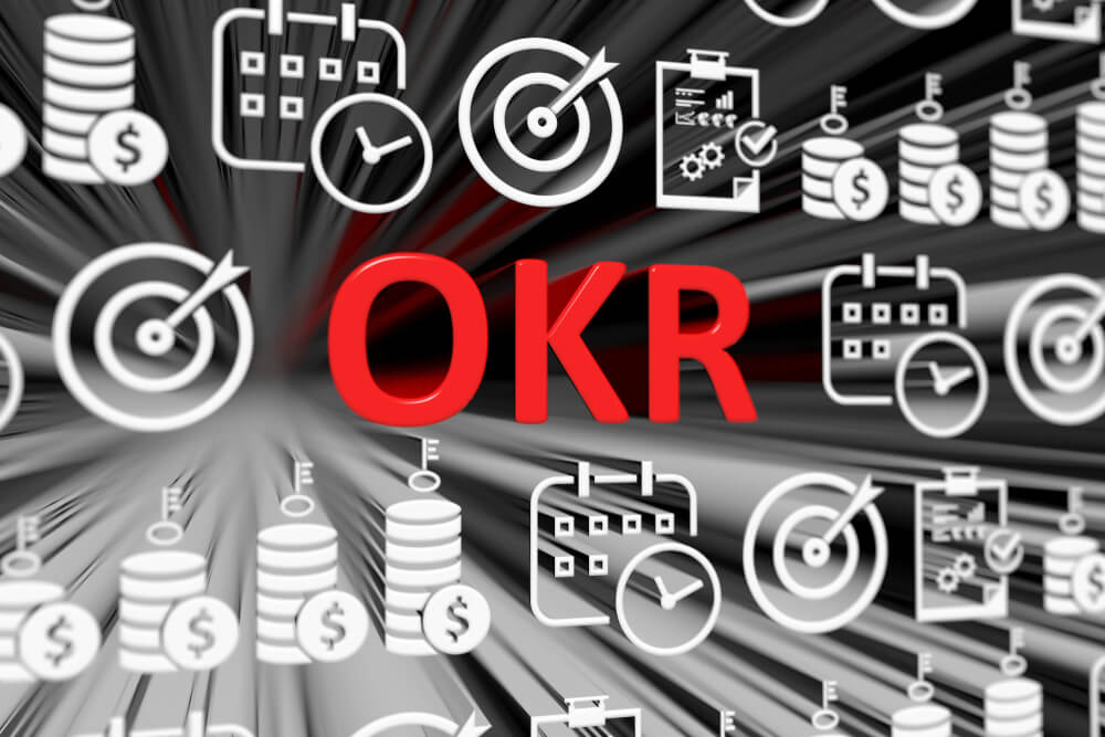 ilustração da sigla OKR em destaque ao meio de símbolos relacionados