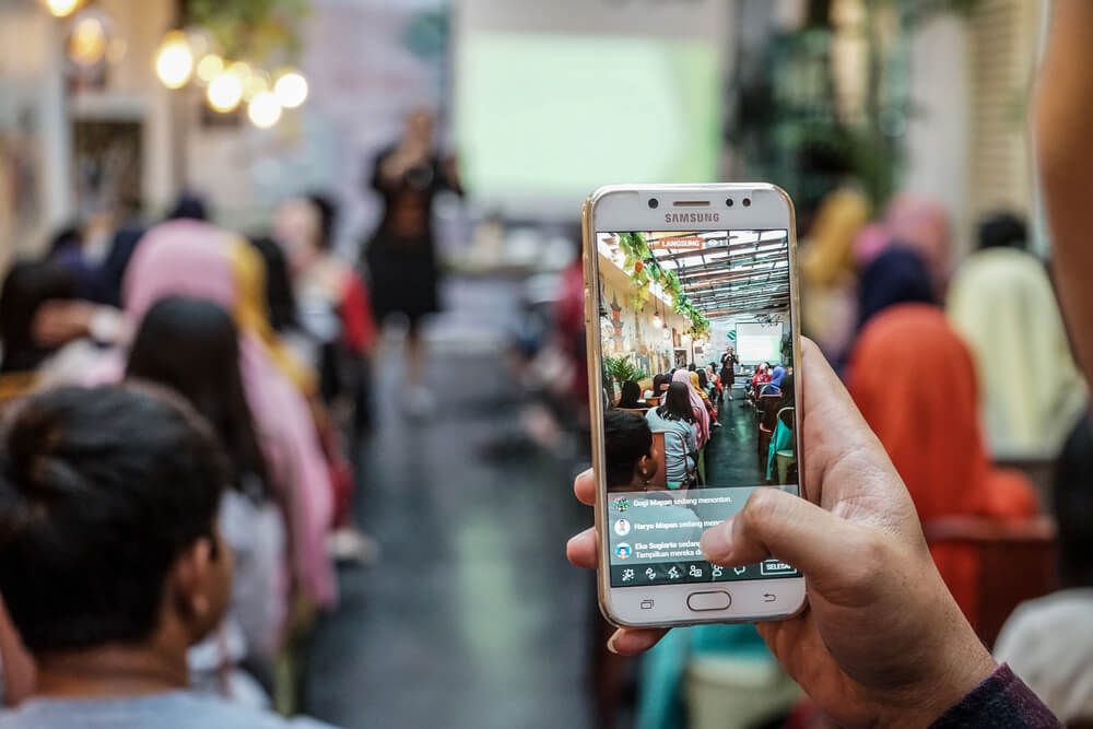 mao masculina com smartphone gravando evento 