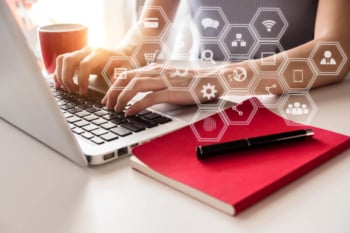 maos femininas em teclado de laptop com bloco de notas e xicara de cafe ao lado e ilustraçao de simbolos de marketing