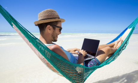 nomade digital trabalhando em seu laptop em rede na praia