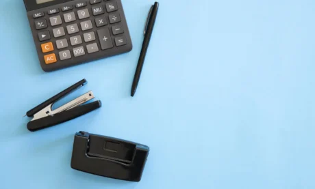 calculadora e materiais de escritório em fundo azul