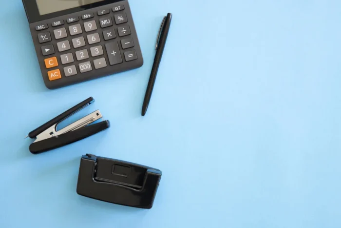 calculadora e materiais de escritório em fundo azul