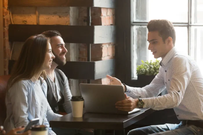 vendedor em frente a-clientes com um laptop em mãos