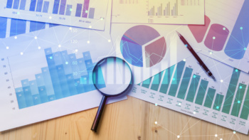 gráficos de estudo de mercado junto de lupa em mesa