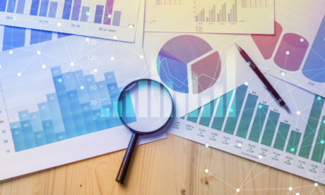 gráficos de estudo de mercado junto de lupa em mesa