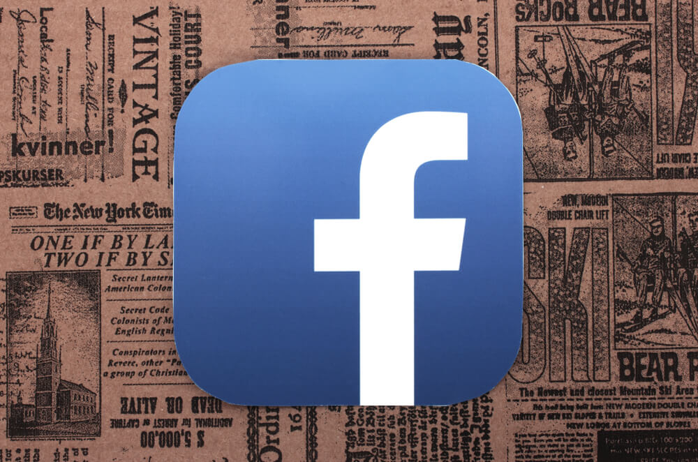 logotipo do facebook em fundo de artigos de jornal