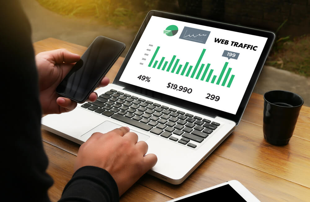profissional acessando laptop com dados de tráfico pago de web
