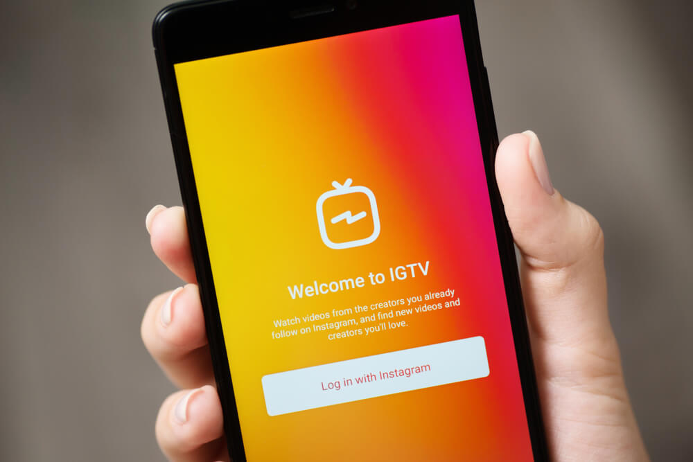 mao segurando smartphone com plataforma IGTV em tela