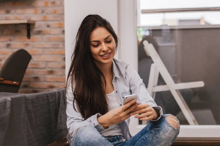 mulher sentada focada em smartphone em maos