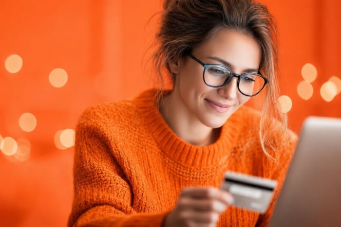 Mulher utilizando notebook e cartão de crédito para compras no e-commerce no Brasil