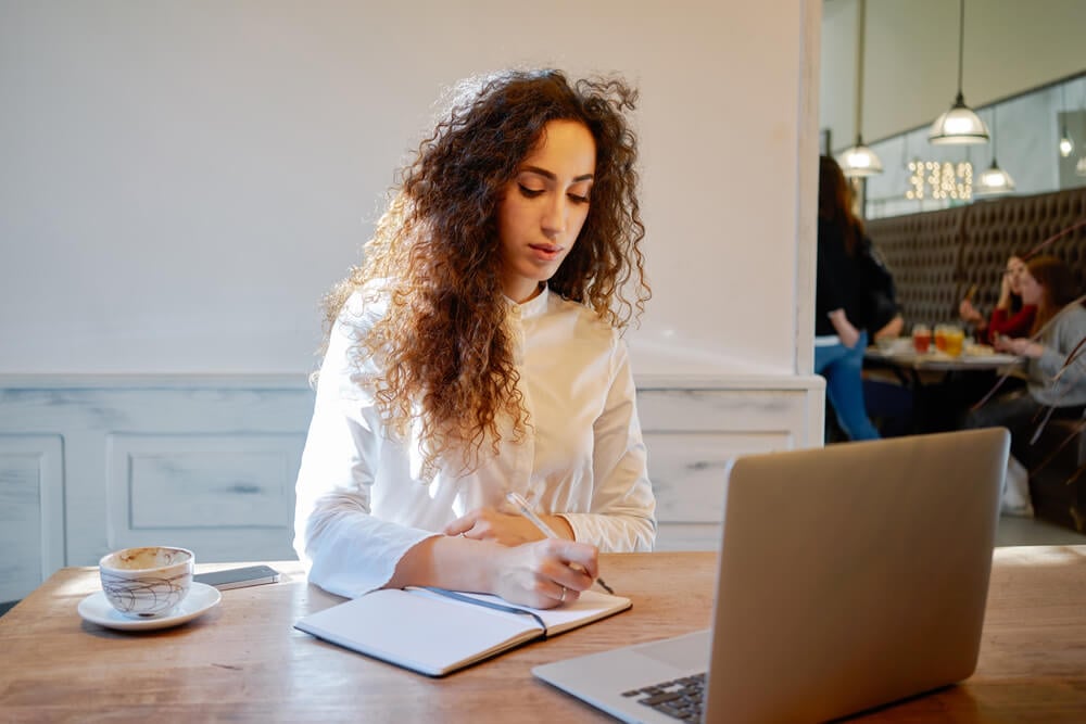 garota trabalhando m frente ao laptop em seu marketing pessoal