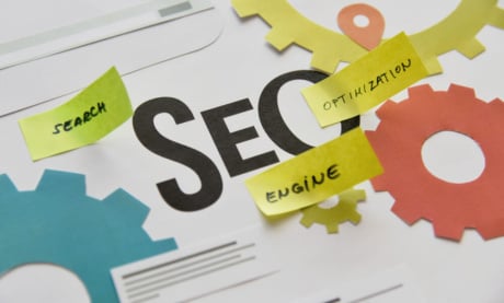 ilustraçao de engrenagens com a palavra SEO em destaque e post its com as palavras search, optimization e engine