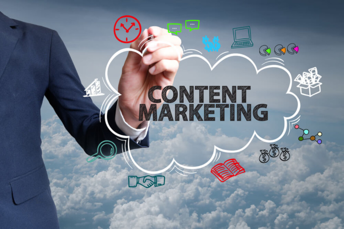 profissional escrevendo título junto de símbolos do marketing de conteudo