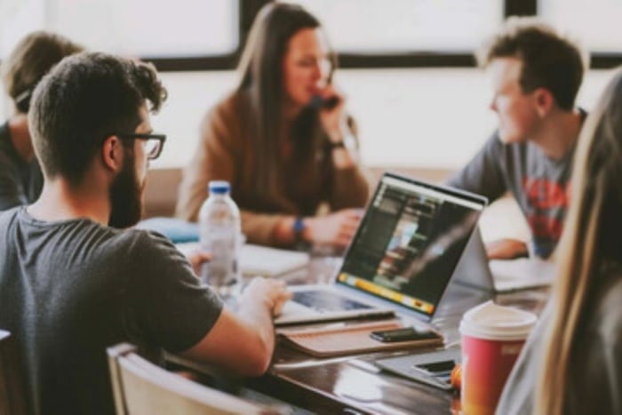 Equipe reunida em escritório discutindo estratégias sobre como escolher uma agência de marketing digital para minha empresa