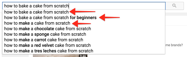 "how to bake a cake" typed into YouTube's search box with red arrows pointing to "beginners" and "scratch" twice in the suggestion box.