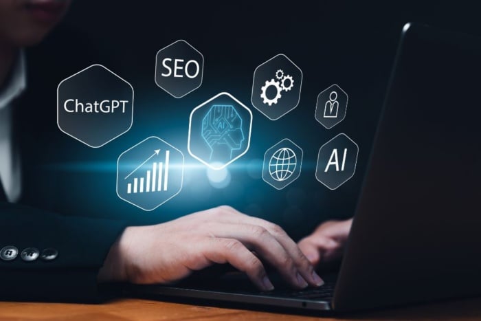 Mão digitando no teclado de um notebook enquanto ícones hexagonais brilhantes flutuam no ar com os termos ChatGPT, SEO, AI, gráficos de crescimento orgânico e engrenagens mecânicas