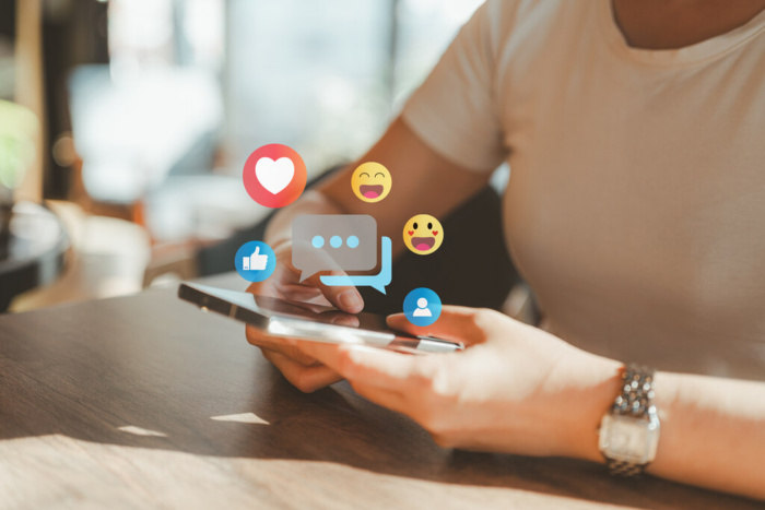 símbolos de emojis de redes sociais surgindo em uma tela de celular