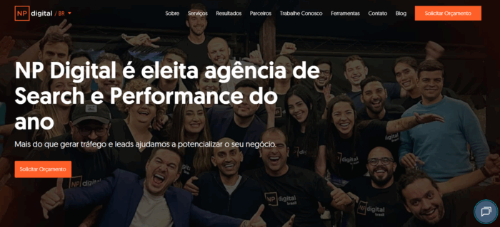 time da Neil Patel no fundo da página inicial da NP Digital Brasil com frase que afirma que NP Digital foi eleita agência de Search e Performance do ano.
