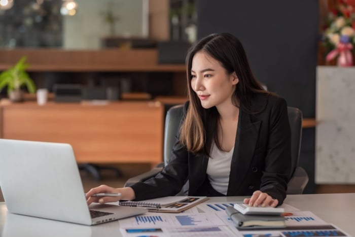 uma mulher mechendo no computador em um escritório