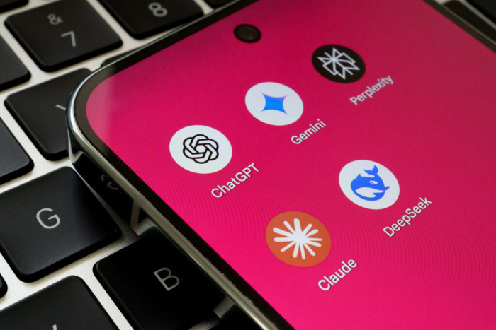 Tela de celular mostrando ícones de aplicativos de inteligência artificial como ChatGPT, Google Gemini, Perplexity, DeepSeek e Claude AI, posicionados sobre o teclado de um laptop. A imagem simboliza a competitividade entre os principais modelos de linguagem do ecossistema de LLMs.