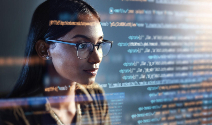 Sviluppatrice osserva il codice sul monitor, analizzando dati e implementando soluzioni tecniche per il web