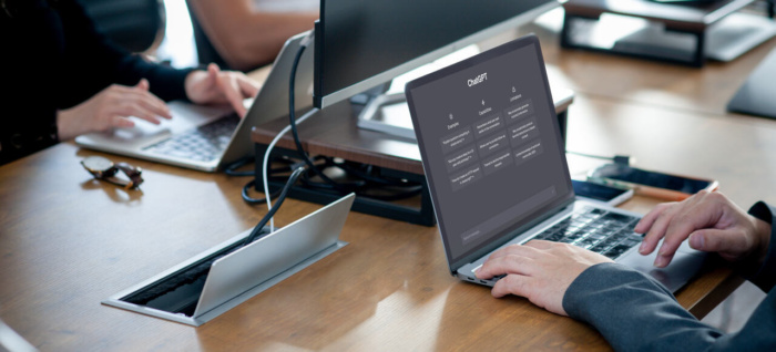 Persona che lavora al computer con ChatGPT aperto sullo schermo, in un ambiente d’ufficio moderno.