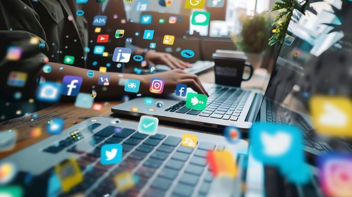 Profissional digitando em laptop cercado por ícones de redes sociais, representando diferentes canais de marketing digital e mostrando como fazer um briefing eficiente para estratégias multicanal