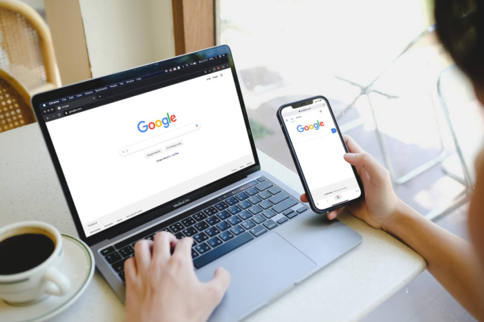 Pessoa usando o Google no computador e no celular, representando o que é share of search e como aplicar no marketing
