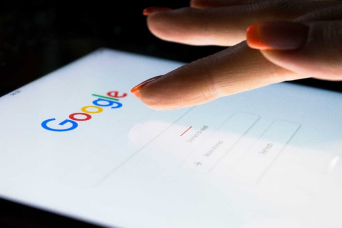 Uma pessoa mexendo em um tablet no google