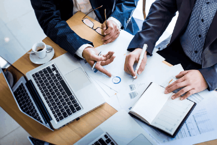 pessoas em uma mesa tentando escolher uma consultoria de marketing