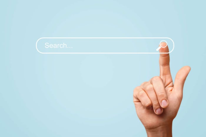 uma mão na barra de pesquisa do google, simbolizando uma pessoa buscando algo no mecanismo de busca