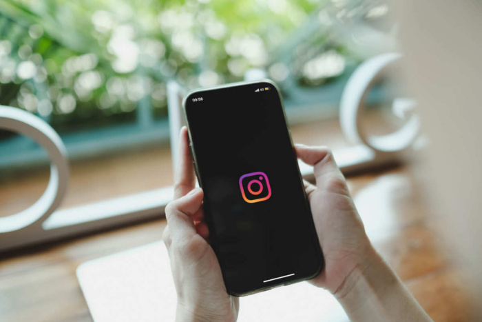 uma pessoa com o celulr na mão aberto no instagram