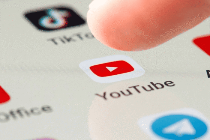 uma pessoa clicando no youtube no celular