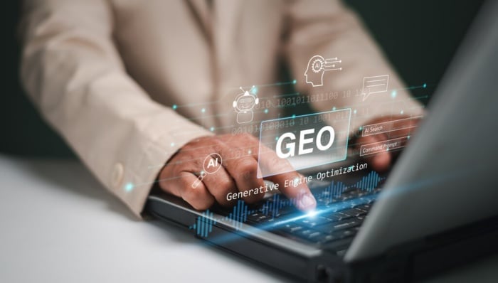 Pessoa digitando em computador com ícones de GEO e elementos relacionados.