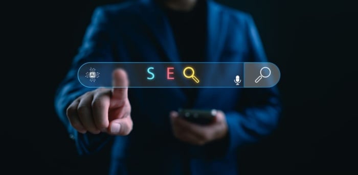 Profissional interagindo com uma barra de pesquisa digital com ícones de inteligência artificial e busca, representando estratégias de SEO B2B e novas formas de pesquisa online.